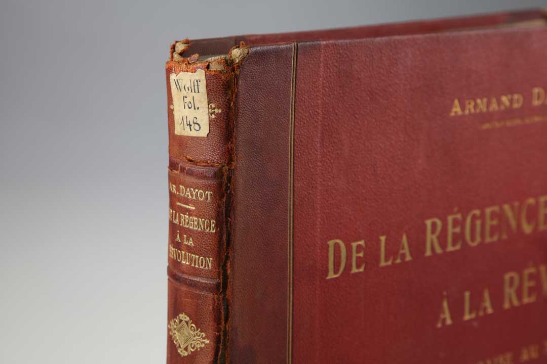 Foto eines historischen, beschädigten Buches aus dem 18. Jahrhundert: Dayot, Armand: De la Régence à la Révolution. Paris : Flammarion, 1906. Signatur: WOLF.FOL148. 