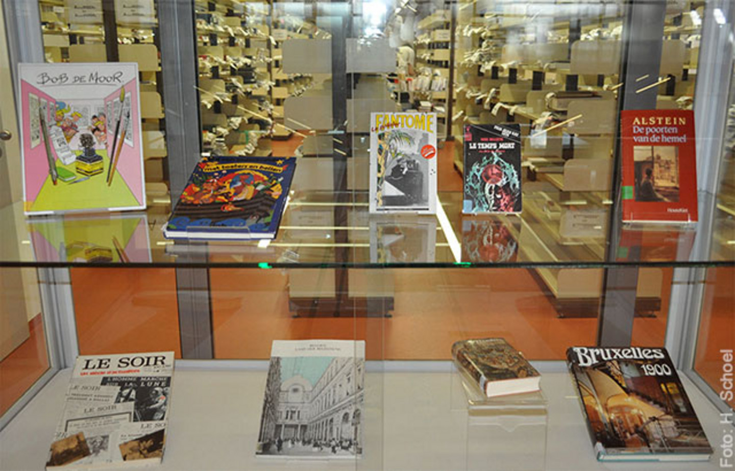 Ein Foto der Ausstellung "Die Bibliothek des Belgischen Hauses" die den Querschnitt des Bibliotheksbestandes zeigt. In einer Vitrine stehen mehrere Bücher.
