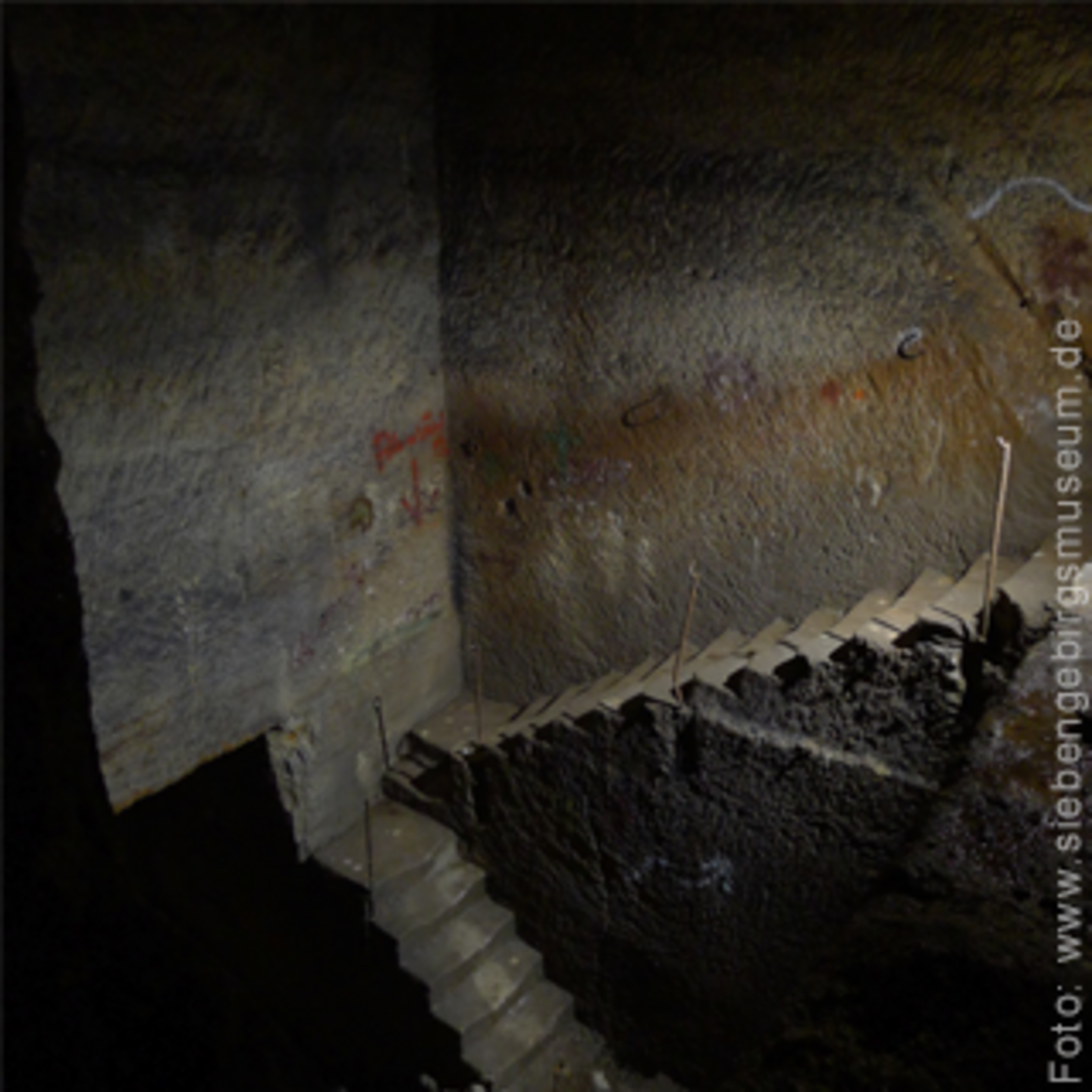 Foto einer steinigen Treppe, es ist sehr dunkel und wirkt kalt.