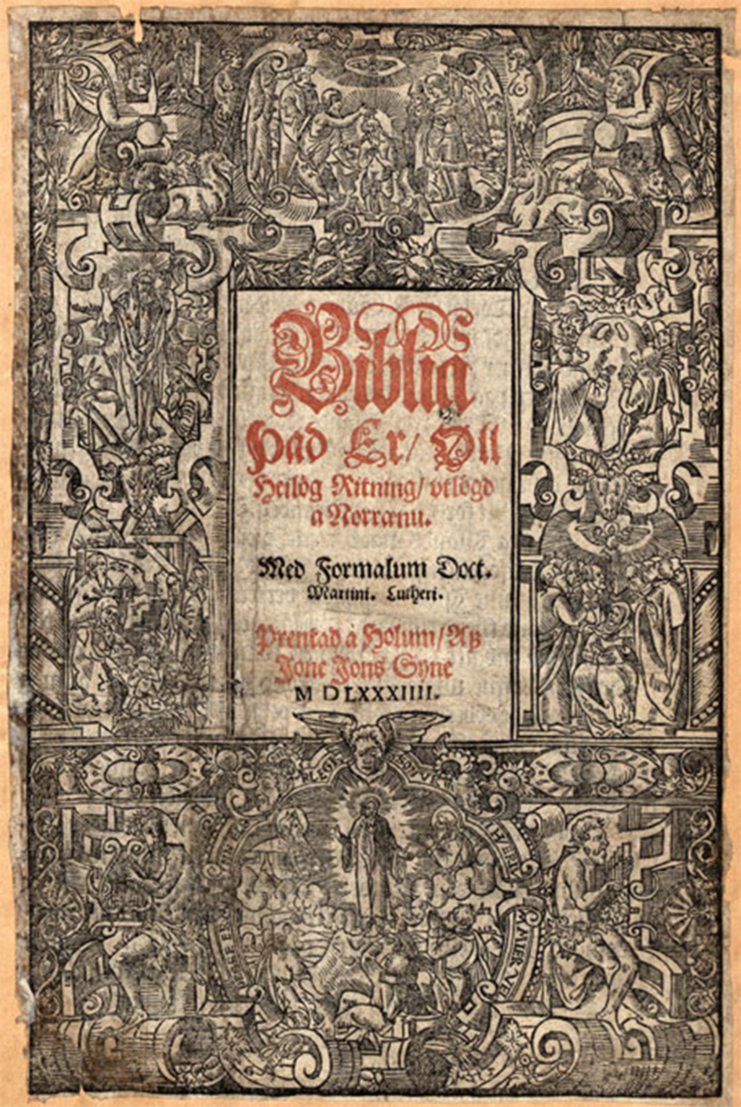 Frontseite einer Bibel aus dem Jahr 1584 umrahmt von religiösen Symbolen und Zeichnungen.