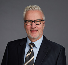 Portraitbild von Thomas Bähr, graue Haare, Brille, Anzug