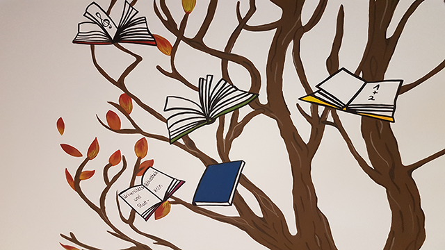 Gemalter Baum an der Wand, im Baum hängen Bücher
