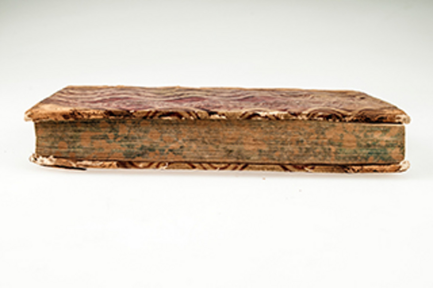 Foto eines historischen, beschädigten Buches von der Seite.