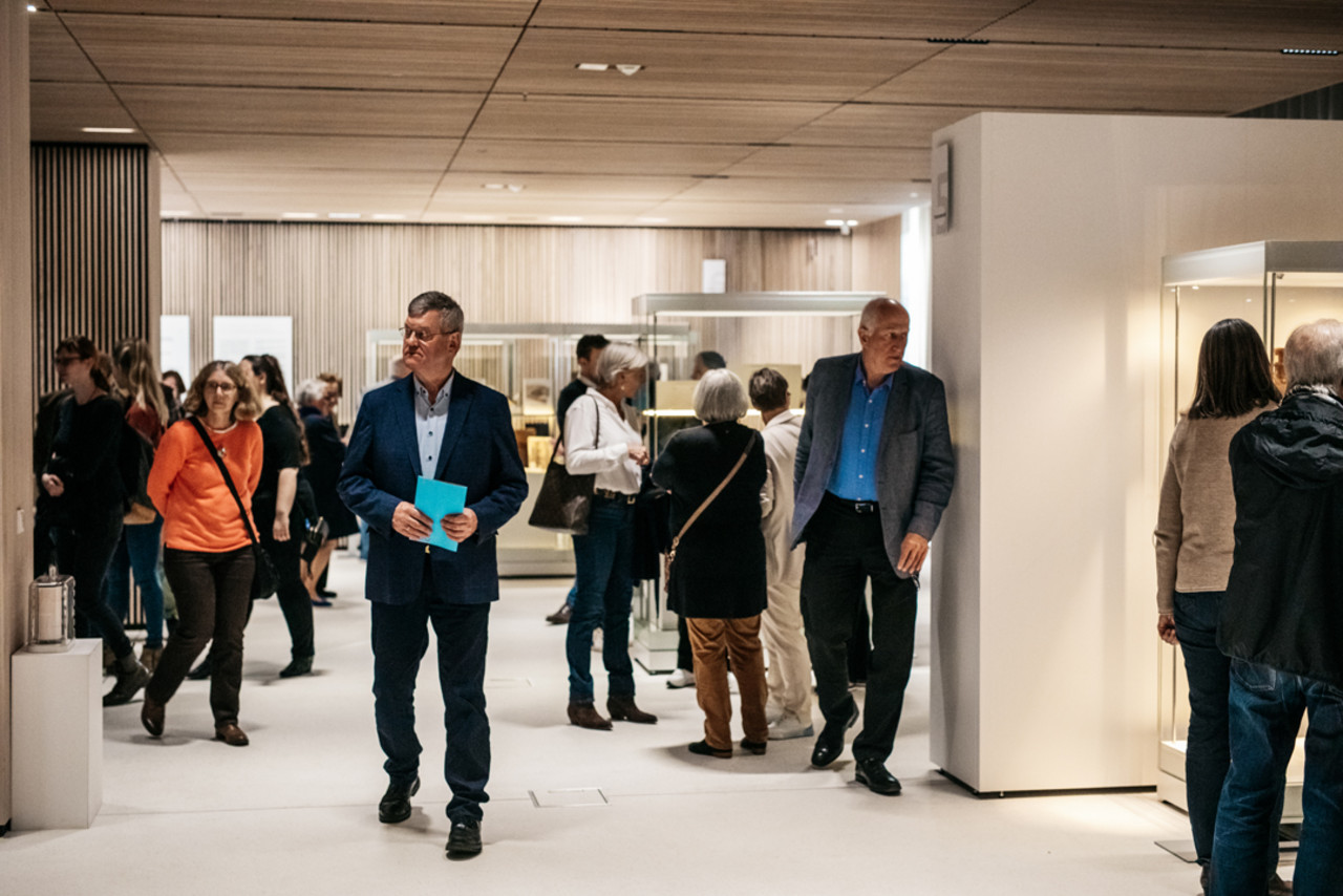 Besucher*innen gehen durch den Ausstellungsraum.