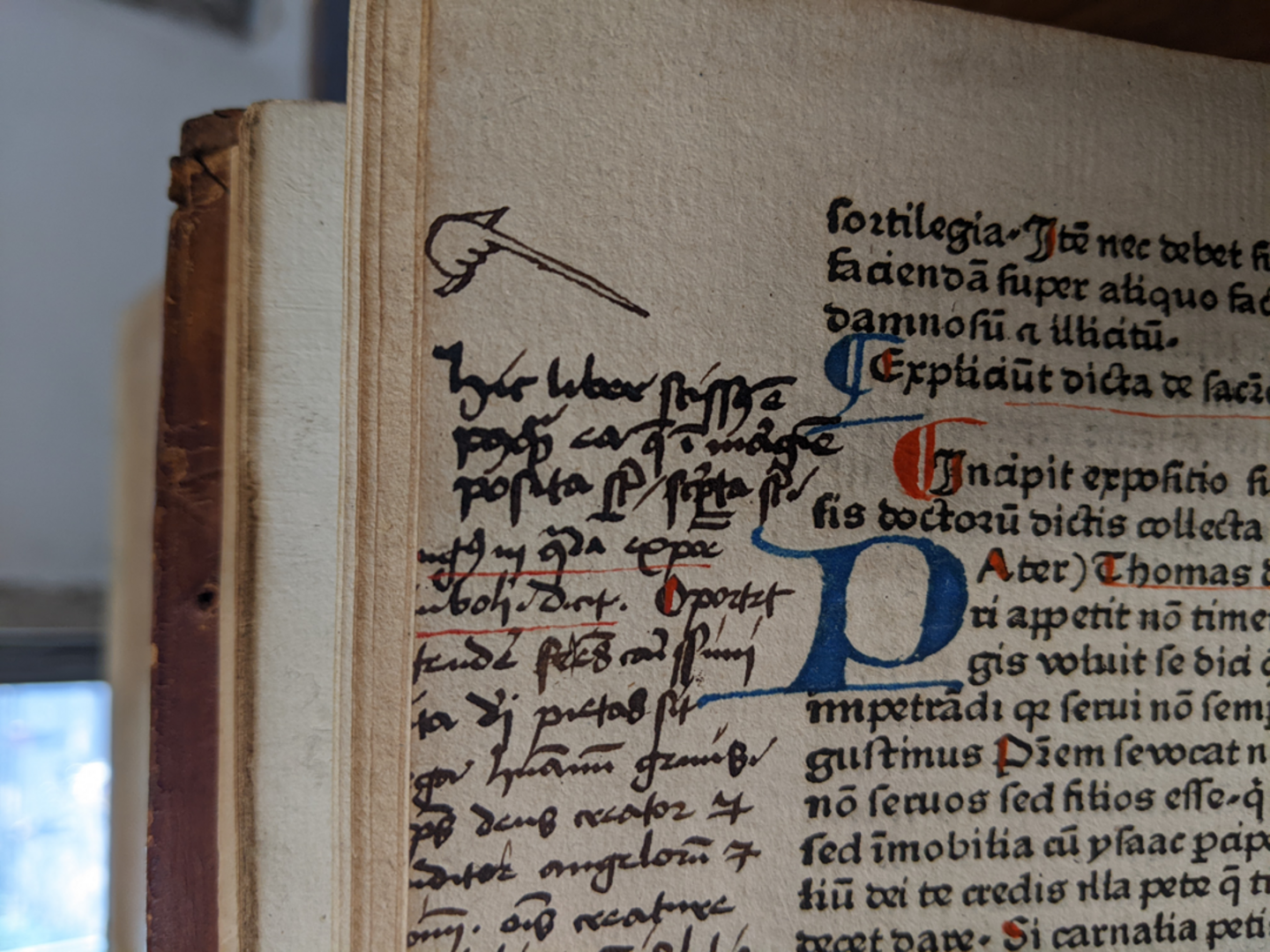 Foto der Inkunabelseite, die neben den gedruckten Text einen handschriftliche Notiz hat. Über der Randnotiz ist eine Hand gezeichnet, die auf die Notiz wahrscheinlich aufmerksam machen soll.