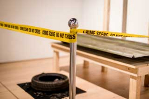 A place cordoned off with yellow tape with the words "Crime Scene - Do not Cross".