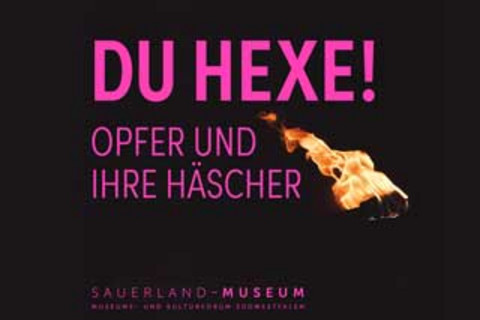 Exhibition motif with the purple writing "DU HEXE! Victims and their Haters". The background is black and a fire is depicted.