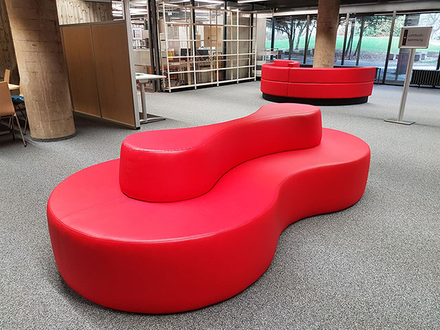 Red leather seating island in group study room